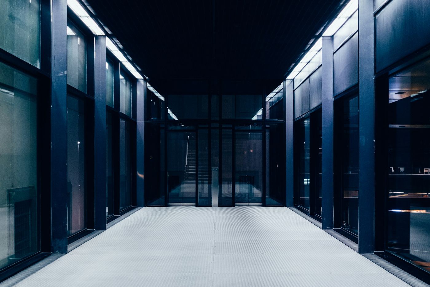 Corridor of a modern data hall lit in blue